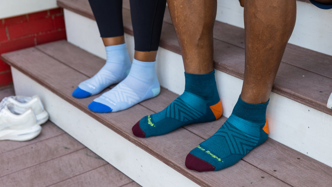 Men's and Women's Ultra-Lightweight Quarter running socks featured on Model  on a set of stairs.