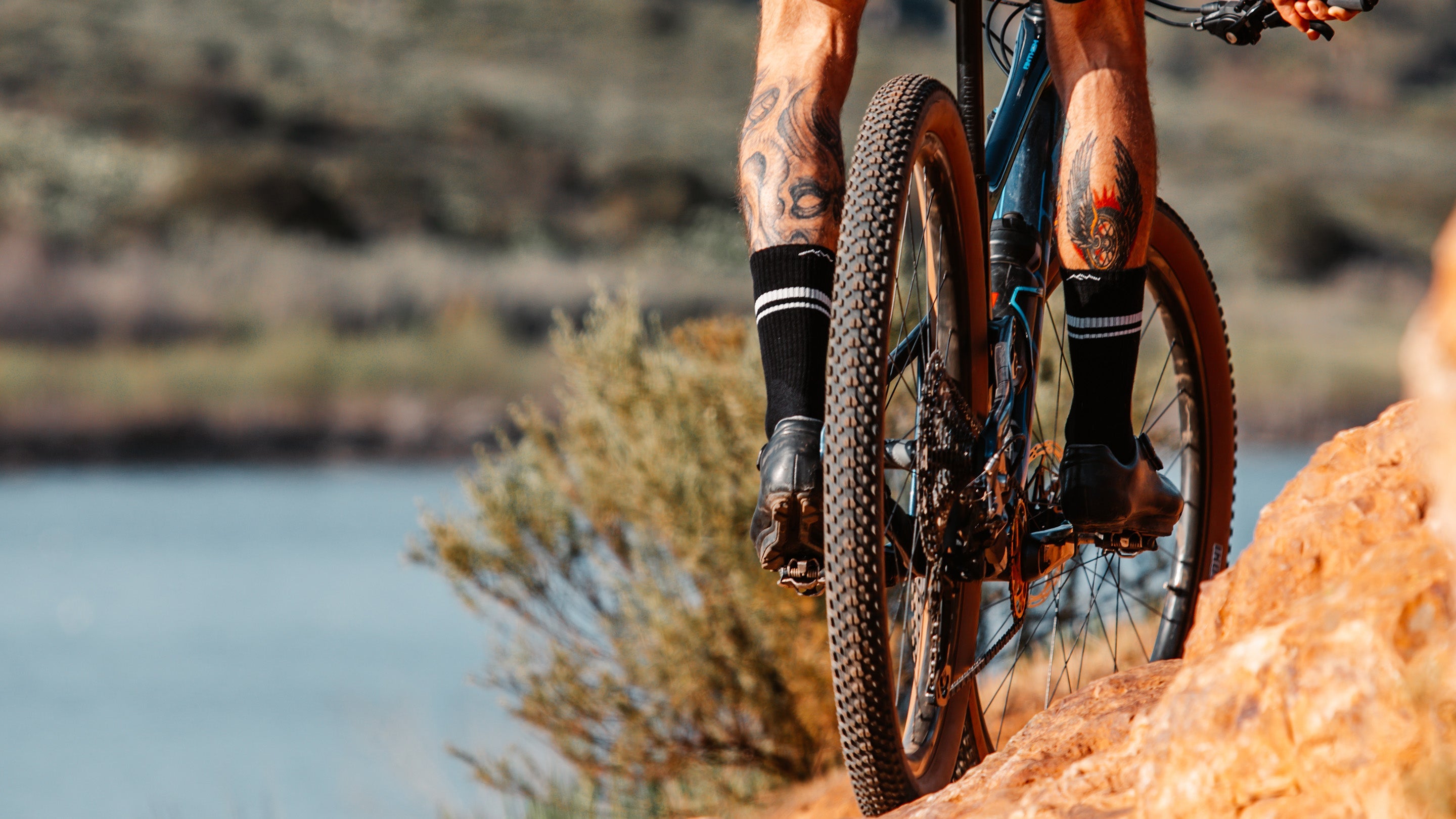 Low view of a mountain biker on a steep slope wearing darn tough athletic socks