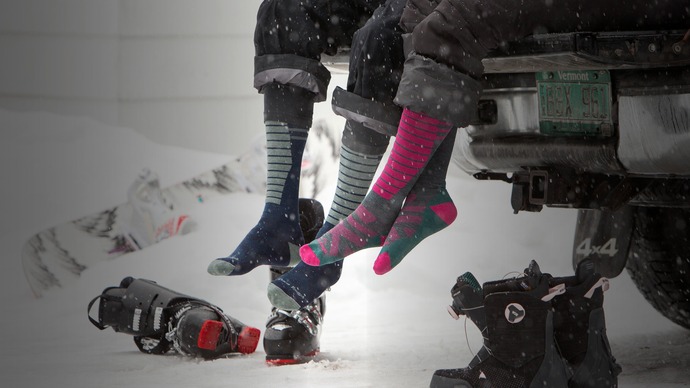 Skier and snowboarder pulling on boots over their merino wool ski socks and snowboard socks