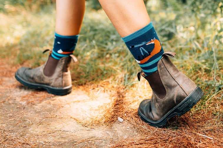 Shop Lifestyle Socks - model on a hiking trail wearing the women's animal haus lifestyle sock in eclipse with an orange fox