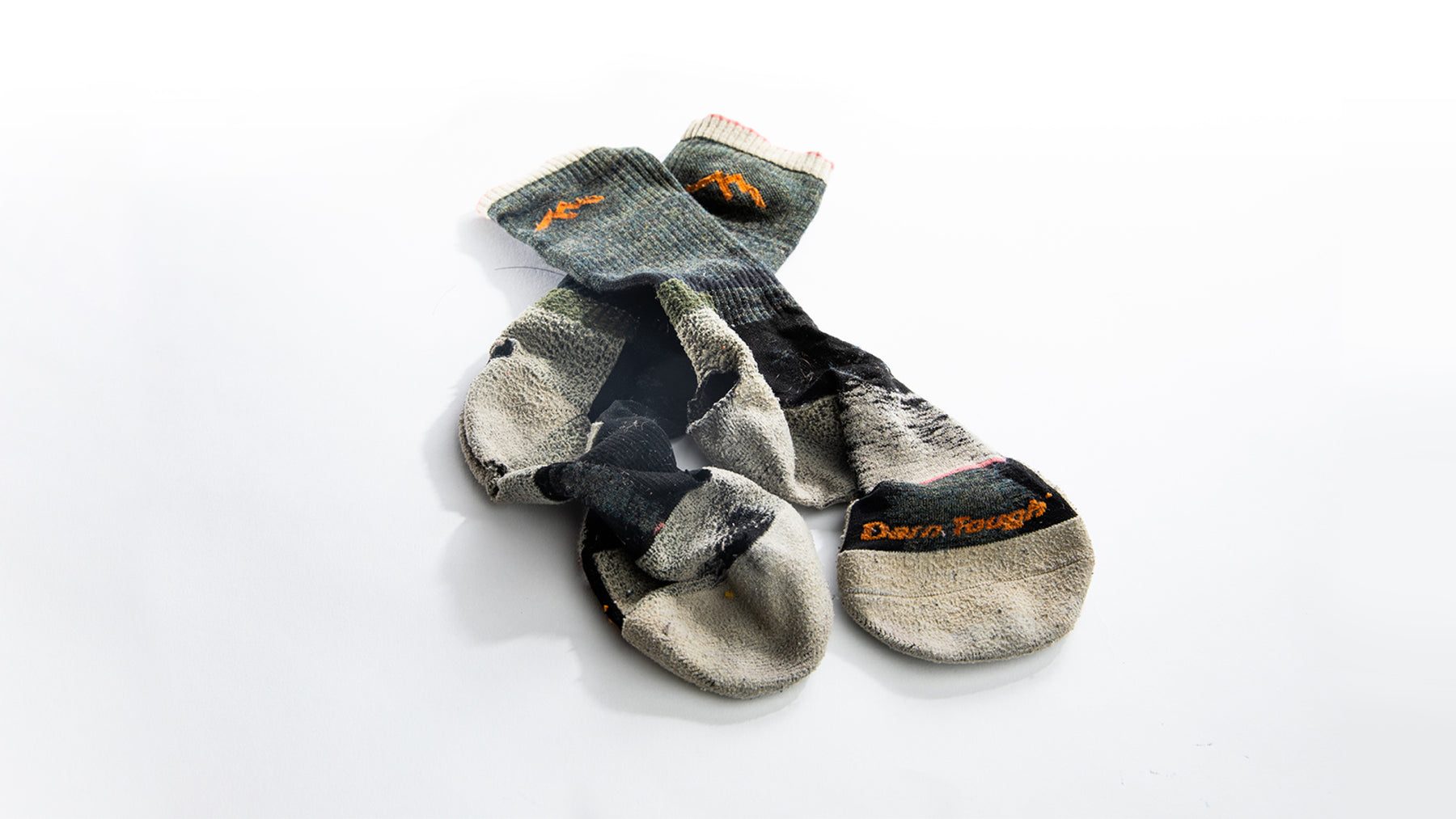 A pair of darn tough socks with holes that are ready to be sent to our warranty team